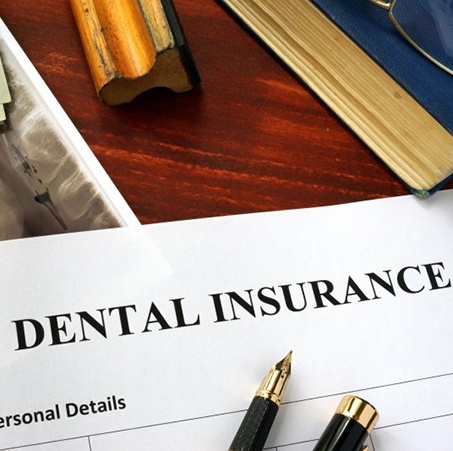a dental insurance form on a wooden table
