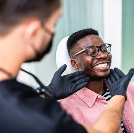 Dentist looking at patient's smile in treatment room