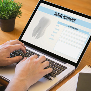 Patient filling out dental insurance form on computer