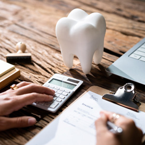 Patient calculating cost on desk with laptop