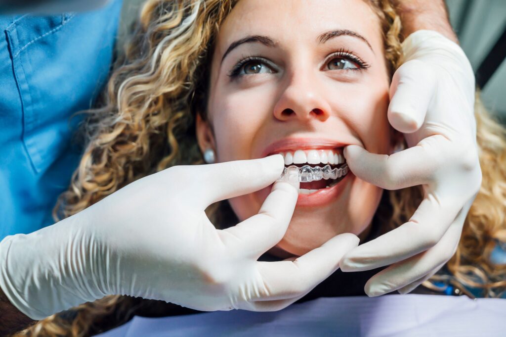 Dentist placing Invisalign over patient's upper arch