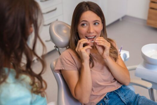 Female patient inserting a clear aligner.