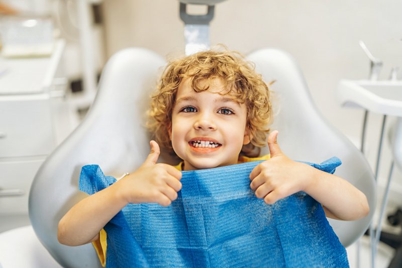 Young patient smiling and giving thumbs-up before Phase 1 orthodontics